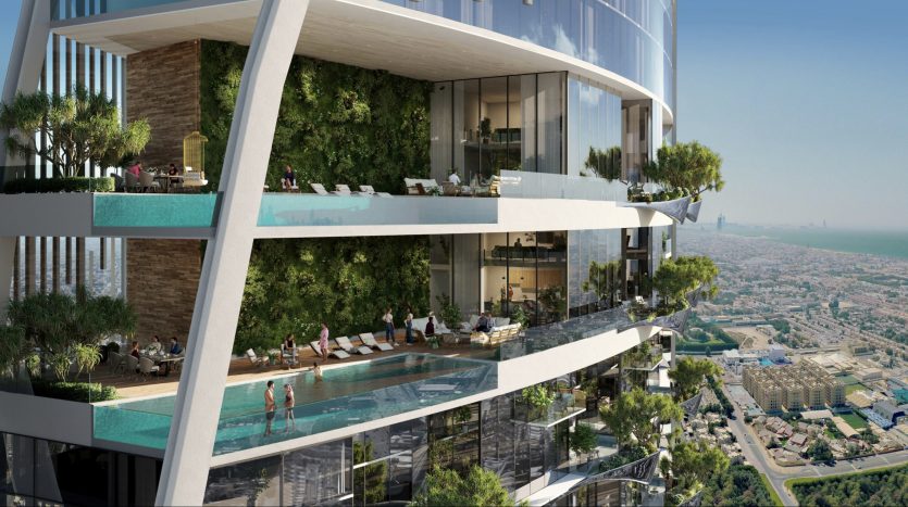 Un immeuble moderne de grande hauteur à Dubaï avec des balcons à plusieurs niveaux dotés de piscines transparentes, d'une verdure luxuriante et de personnes profitant d'une journée ensoleillée avec vue sur la ville en arrière-plan.