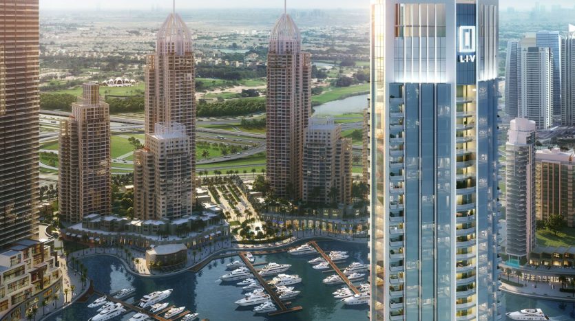 Une vue panoramique d&#039;un complexe luxueux en bord de mer avec des immeubles de grande hauteur, une marina remplie de yachts et un environnement paysager sous un ciel bleu clair, mettant en valeur des immeubles d&#039;appartements de premier plan à Dubaï.