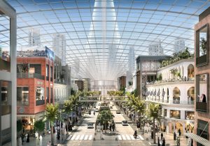 Intérieur d'un centre commercial moderne à Dubaï avec un plafond transparent, comprenant des magasins à plusieurs niveaux, des sentiers piétonniers et une verdure luxuriante, éclairés par la lumière naturelle.
