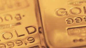 Gros plan de lingots d'or avec « or 999,9 » gravé sur leur surface, soulignant leur grande pureté. L'accent est mis sur le texte avec un fond doré doux rappelant le luxueux