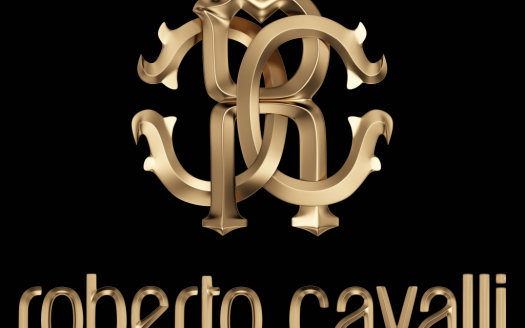 Logo 3D doré de Roberto Cavalli comportant les lettres stylisées "RC" avec d'élégants tourbillons, positionnées au-dessus du nom de la marque en minuscules sur fond noir, représentant l'opulence