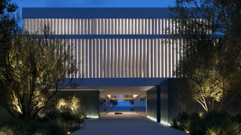 Bâtiment moderne éclairé au crépuscule avec des lignes horizontales et une entrée symétrique encadrée d&#039;arbres, représentant une agence immobilière Dubaï exemplaire.