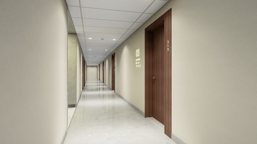 Un long couloir moderne dans un appartement à Dubaï avec des portes en bois d&#039;un côté et un mur vert pâle de l&#039;autre, éclairé par des plafonniers lumineux et marqué de numéros de pièce.