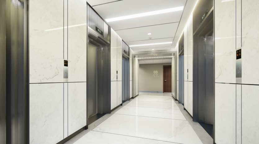 Un hall d&#039;ascenseur moderne avec des sols et des murs en marbre, comprenant deux ascenseurs avec indicateurs d&#039;étage numériques et un couloir menant à une porte marquée « 03 » dans un immeuble prestigieux de l&#039;immobilier de Dubaï.