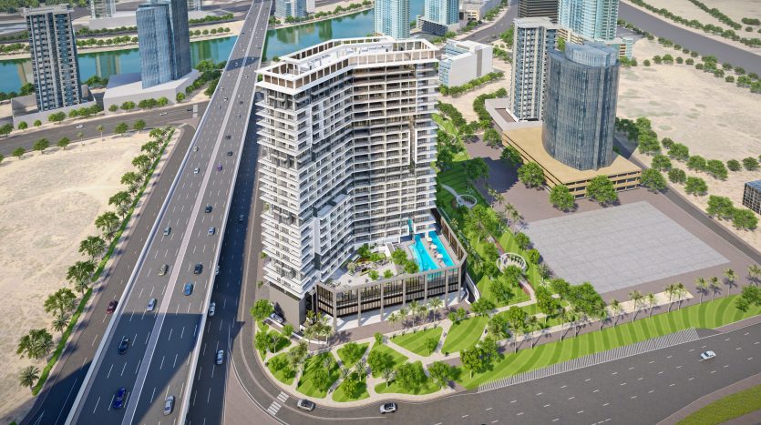 Vue aérienne d&#039;un immeuble moderne à plusieurs niveaux avec piscine, situé dans un coin de ville près d&#039;une autoroute à Dubaï, avec des gratte-ciel voisins et une rivière.