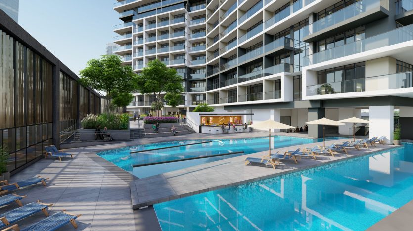 Un espace piscine extérieur luxueux d&#039;un complexe résidentiel moderne à Dubaï, doté de chaises longues, de parasols et d&#039;un bar adjacent, entouré d&#039;une verdure luxuriante et d&#039;immeubles de grande hauteur contemporains.