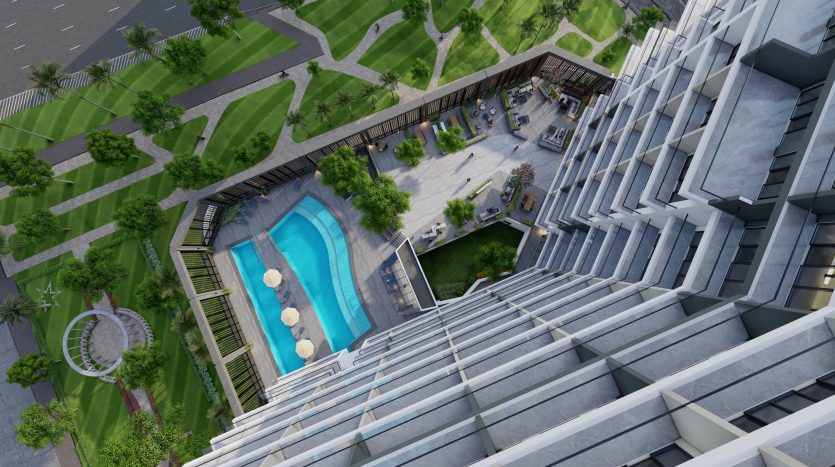 Vue aérienne d&#039;un complexe résidentiel moderne à Dubaï comprenant une piscine extérieure, des jardins paysagers et une cour animée avec des cafés et des gens.