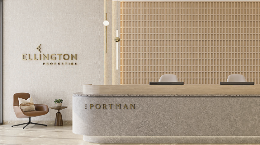 Zone de réception moderne comprenant un bureau incurvé élégant avec le nom « Portman » sur le devant, un mur texturé avec le logo « Ellington Properties », des lattes en bois et une élégante chaise marron