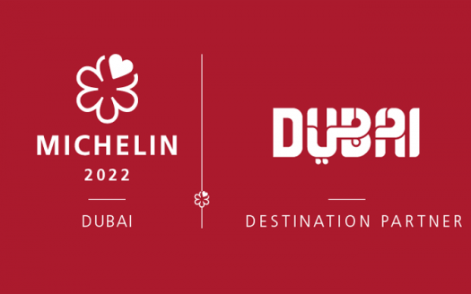 Une image promotionnelle montrant un partenariat pour le Guide Michelin 2022 avec Villa Dubai comme destination partenaire. Les logos Michelin et Dubaï sont mis en évidence sur fond rouge.