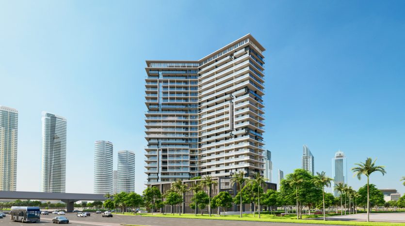 Un immeuble résidentiel moderne de grande hauteur avec de grands balcons, situé dans une zone urbaine avec un aménagement paysager verdoyant et plusieurs autres gratte-ciel sous un ciel bleu clair, parfait pour ceux qui s&#039;intéressent à l&#039;immobilier Dubaï.