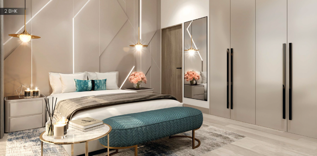 Chambre moderne dans un appartement de Dubaï comprenant un lit soigneusement fait avec une literie blanche et bleu sarcelle, un éclairage de chevet élégant, une armoire à miroir et une petite table ronde avec des objets décoratifs.
