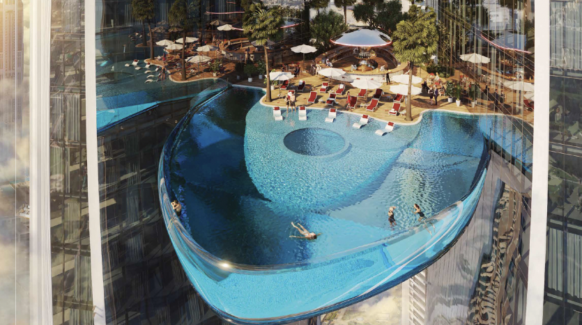 Vue aérienne d&#039;une piscine d&#039;hôtel luxueuse et moderne avec un fond de verre unique, surplombant le paysage urbain de Dubaï, avec des gens nageant et se prélassant autour de transats ombragés.