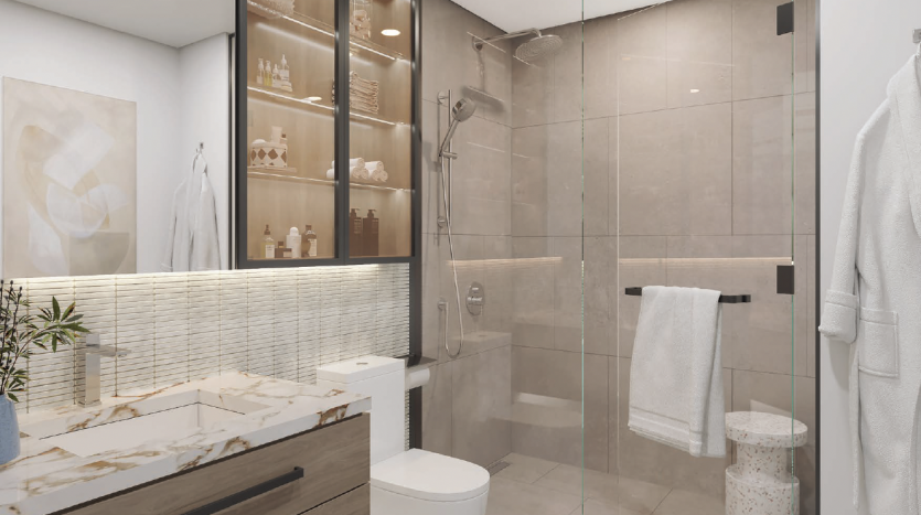 Salle de bains moderne dans une villa de Dubaï comprenant une cabine de douche en verre, des toilettes blanches, une vasque avec comptoir en marbre, un grand miroir et des étagères avec articles de toilette. Une petite plante en pot ajoute une touche de