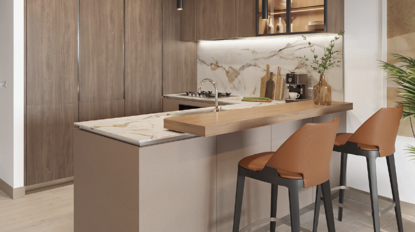 Intérieur de cuisine moderne dans un appartement de Dubaï comprenant des armoires en bois, un dosseret en marbre et un îlot avec deux tabourets marron. Le design intègre des tons neutres chauds et des finitions élégantes.