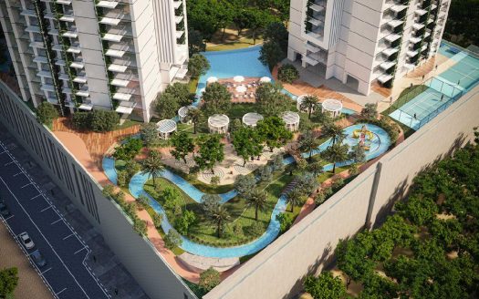 Vue aérienne d'un complexe résidentiel luxueux à Dubaï comprenant des piscines incurvées, une verdure luxuriante, des espaces de détente et des immeubles modernes de grande hauteur par une journée ensoleillée.
