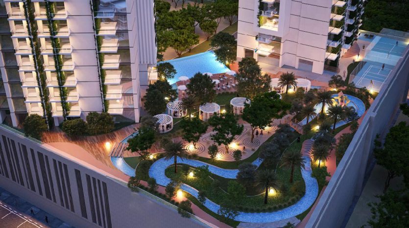 Vue aérienne d'un complexe résidentiel luxueux à Dubaï la nuit, avec des allées éclairées, une piscine, une verdure luxuriante et des immeubles de grande hauteur modernes.