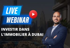 Un professionista in abito da lavoro si trova di fronte ai tetti di Dubai con una grafica in sovraimpressione che promuove un webinar dal vivo intitolato "Investire in appartamenti a Dubai" con un pulsante di riproduzione di YouTube.