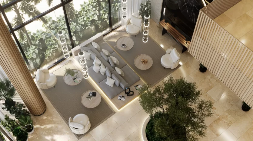 Vue aérienne d&#039;un luxueux salon intérieur dans une villa de Dubaï au décor moderne, comprenant des canapés, des chaises et des tables basses, entouré de grandes fenêtres mettant en valeur la verdure luxuriante à l&#039;extérieur.