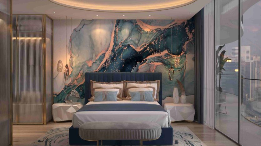 Une chambre moderne dans un appartement de Dubaï comprenant un grand lit avec une literie douce bleue et beige, un pouf assorti à ses pieds et de superbes décorations murales en marbre bleu et or. La pièce a un éclairage chaleureux