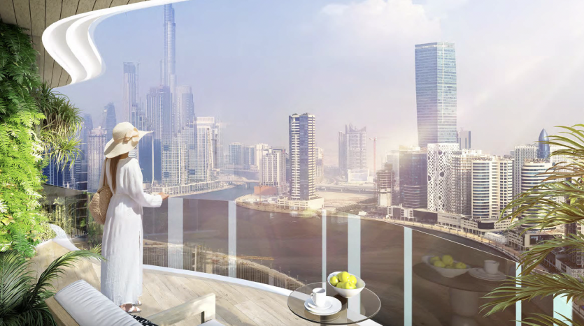 Une femme vêtue d&#039;une robe blanche et d&#039;un chapeau se tient sur le balcon moderne d&#039;un appartement de Dubaï, regardant un paysage urbain ensoleillé avec des gratte-ciel et une verdure verdoyante.