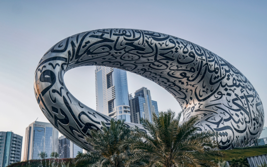 Le musée du futur de Dubaï, doté d'une structure en forme de tore ornée de calligraphies arabes complexes, a pour toile de fond des gratte-ciel et des palmiers. A proximité, une agenceimm