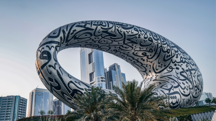 Le musée du futur de Dubaï, doté d&#039;une structure en forme de tore ornée de calligraphies arabes complexes, a pour toile de fond des gratte-ciel et des palmiers. A proximité, une agenceimm