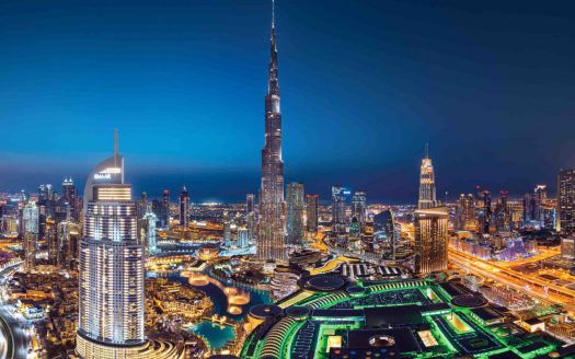 Une vue panoramique nocturne de Dubaï mettant en valeur l'horizon illuminé avec le Burj Khalifa dominant les gratte-ciel environnants, les voies navigables éclairées et les appartements luxueux.