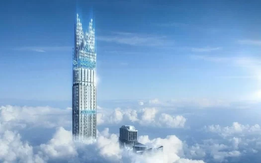 Un gratte-ciel futuriste et imposant s'étend bien au-dessus des nuages dans un ciel bleu clair, mettant en valeur le summum de l'immobilier Dubaï, avec un autre bâtiment plus court partiellement visible à travers la dense couverture nuageuse blanche en contrebas.