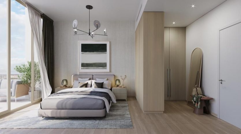 Une chambre moderne dans une villa à Dubaï comprenant un grand lit, une armoire en bois et un balcon attenant. Le décor comprend une peinture abstraite, un miroir pleine longueur et un luminaire subtil.