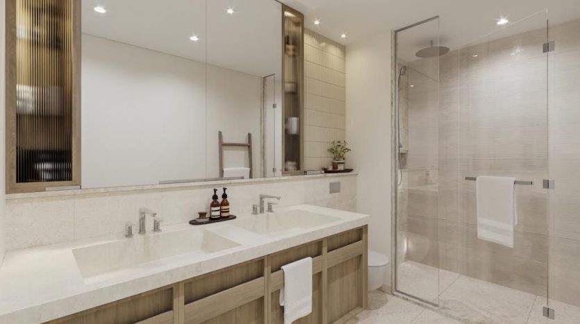 Salle de bain moderne avec double vasque, grands miroirs et espace douche vitré. Palette de couleurs neutres avec des accents de bois et des plantes décoratives, parfaites pour une propriété d&#039;investissement à Dubaï.
