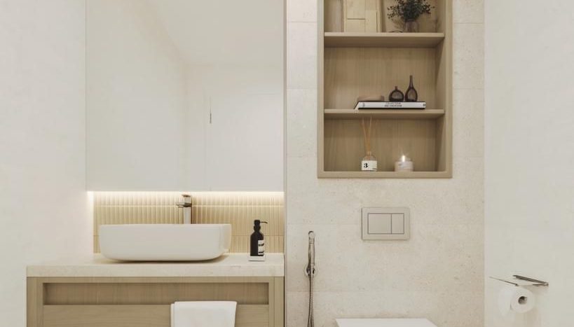 Une salle de bains moderne dans une villa à Dubaï comprenant une vanité en bois avec une vasque ronde, un grand miroir, des toilettes blanches et une étagère murale intégrée avec des articles de toilette et des objets décoratifs. Les murs et le sol