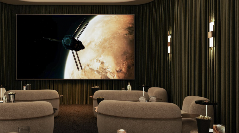 Une salle de cinéma maison luxueuse dans un appartement de Dubaï avec des murs et des rideaux sombres, dotée de grands sièges moelleux et d&#039;un écran géant affichant une scène de vaisseau spatial. Un éclairage doux et des boissons créent une ambiance chaleureuse.