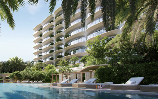 Immeuble d&#039;appartements de luxe moderne à Dubaï avec des balcons incurvés entourés d&#039;une verdure tropicale luxuriante et une piscine avec des chaises longues au premier plan.