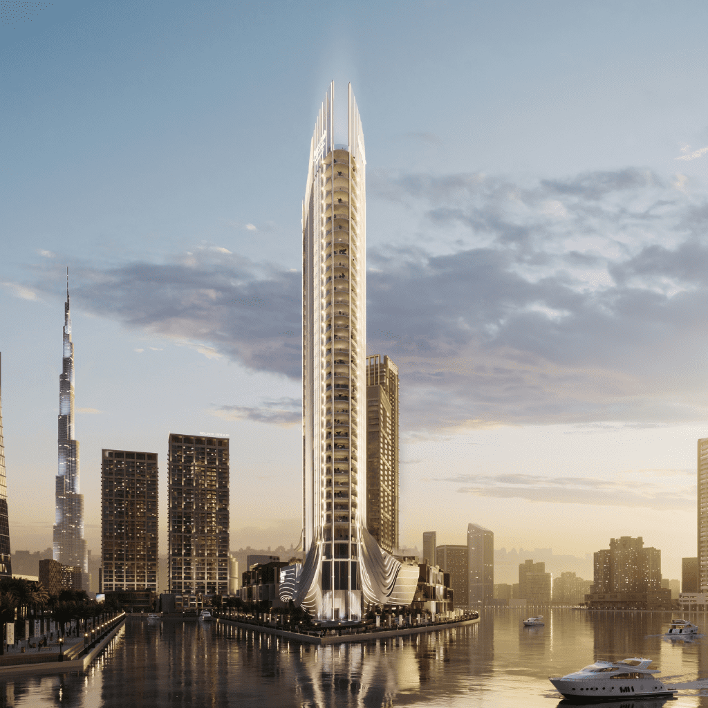 Un gratte-ciel futuriste au design élégant et imposant, situé au bord d'une rivière dans le paysage urbain moderne de Dubaï au coucher du soleil, se reflétant dans l'eau, avec d'autres immeubles de grande hauteur et un yacht à proximité.