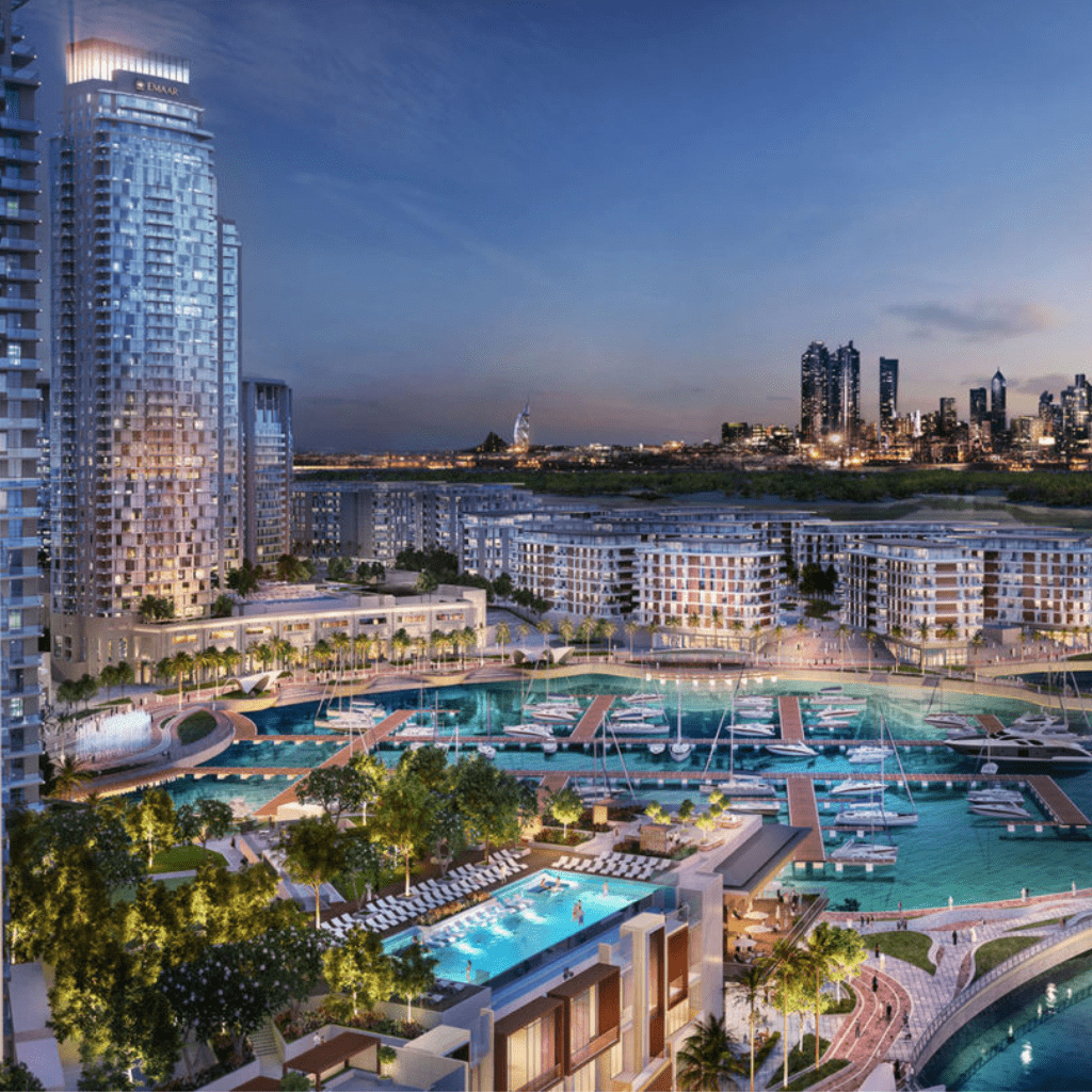 Vue aérienne d'un luxueux complexe riverain au crépuscule à Dubaï, avec des immeubles de grande hauteur, une grande piscine et une marina remplie de bateaux.