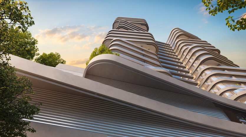 Villa architecturale moderne à Dubaï avec des balcons ondulés et superposés présentant un design futuriste, sur un ciel crépusculaire partiellement obscurci par un feuillage vert luxuriant sur les côtés.