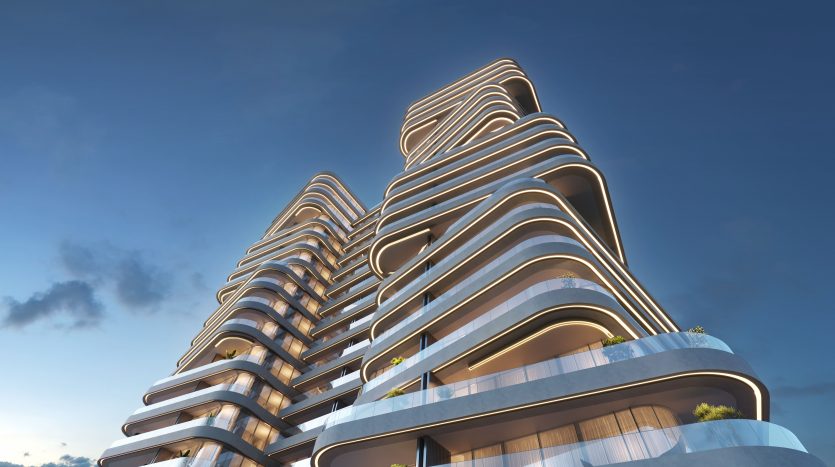 Des bâtiments architecturaux modernes à plusieurs étages avec des balcons fluides et incurvés sur un ciel bleu avec des nuages clairs, mettant en valeur le design futuriste et servant de principales opportunités d&#039;investissement à Dubaï.
