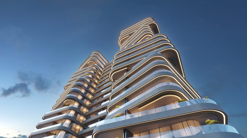 Un immeuble d&#039;appartements futuriste de plusieurs étages à Dubaï avec des lignes architecturales ondulées et fluides sous un ciel bleu clair au coucher du soleil, mettant en valeur le design unique et moderne de la structure.