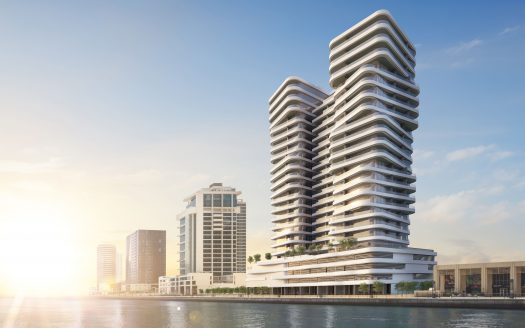 Bâtiments modernes en bord de mer à l&#039;architecture incurvée sous un ciel clair à Dubaï, reflétant le lever du soleil sur les eaux calmes.