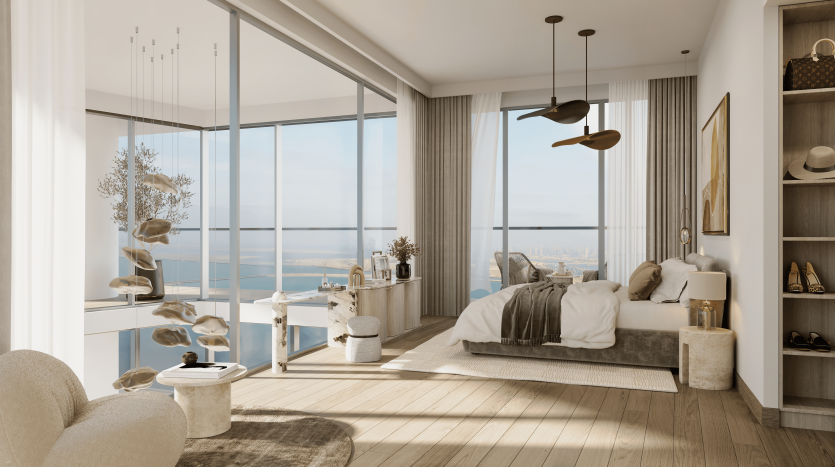Une chambre moderne et spacieuse avec de grandes fenêtres offrant une vue sur l&#039;océan dans un appartement de Dubaï, présentant un design minimaliste avec des tons neutres, un lit king-size, un coin salon et du parquet.