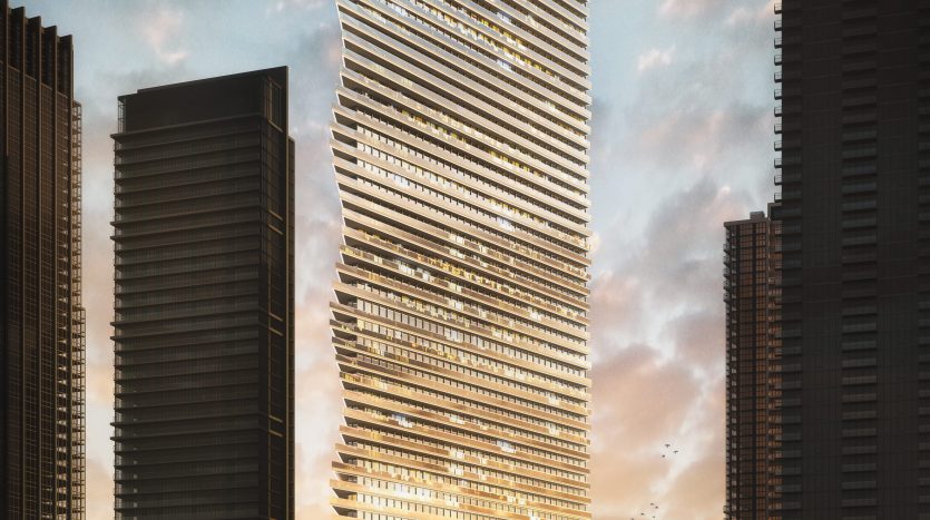 Un gratte-ciel moderne au design unique et torsadé, éclairé par le soleil couchant, aux côtés d&#039;autres grands immeubles au bord d&#039;un front de mer à Dubaï, avec un yacht qui passe par là.