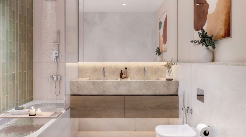 Une salle de bains moderne et spacieuse dans un appartement de Dubaï comprenant une baignoire, une cabine de douche en verre, des toilettes murales et du carrelage aux tons terre. Le décor comprend de l&#039;art abstrait, des plantes vertes et un éclairage tamisé.