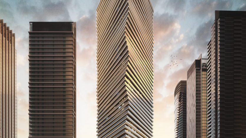 Un imposant gratte-ciel moderne, conçu avec des lignes angulaires nettes et de multiples balcons à facettes en verre, se dresse majestueusement au crépuscule. Entourée d&#039;autres immeubles de grande hauteur à Dubaï, sa façade est