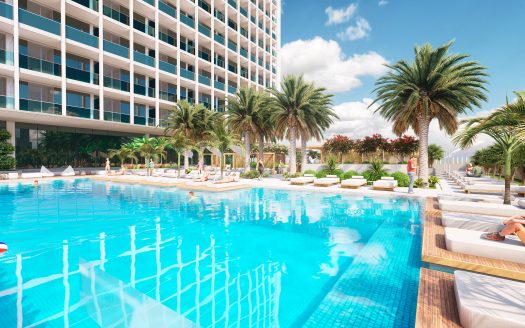 Un espace piscine luxueux dans un complexe hôtelier de grande hauteur à Dubaï, avec des palmiers, des chaises longues et un ciel bleu clair, représentant un lieu de vacances serein et accueillant.