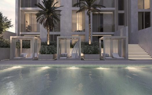 Maison à l'architecture moderne comprenant une piscine au premier plan avec des cabanes éclairées et des palmiers sur fond d'immeuble à plusieurs étages le soir, parfaite pour ceux qui s'intéressent à l'immobilier Dubaï.