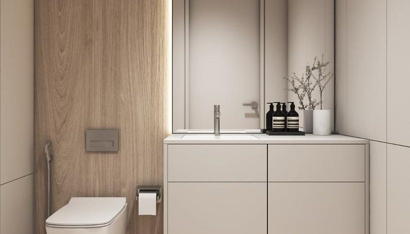 Une salle de bains moderne dans une villa de Dubaï comprenant des toilettes élégantes à côté d&#039;un mur lambrissé, un meuble lavabo blanc intégré et un miroir à l&#039;esthétique minimaliste.