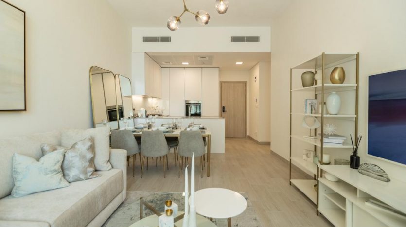 Un salon moderne et bien éclairé se transforme en douceur en une salle à manger, dotée d&#039;une décoration de bon goût, d&#039;un canapé moelleux, d&#039;un ensemble de salle à manger élégant et d&#039;œuvres d&#039;art contemporaines dans une luxueuse villa de Dubaï.