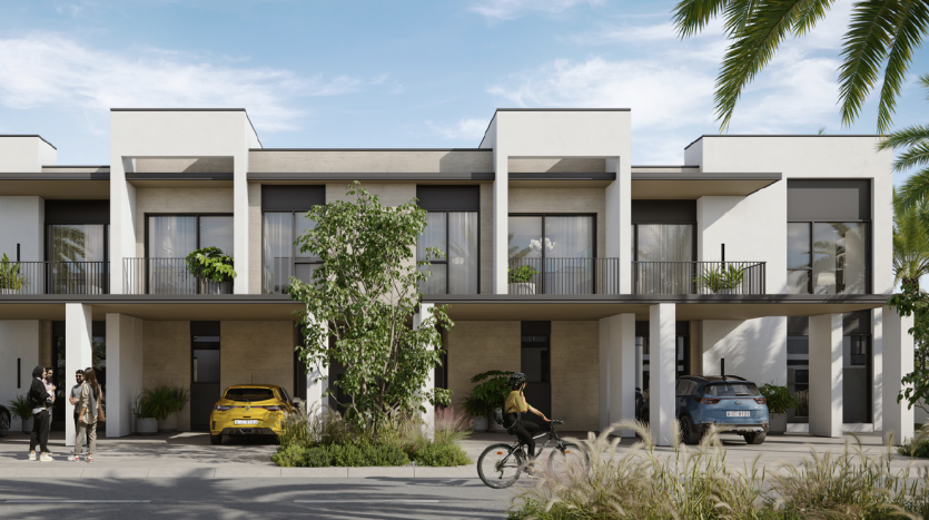 Complexe de villas modernes aux lignes épurées et aux couleurs neutres, avec résidents et véhicules à l&#039;extérieur, entourés d&#039;une verdure luxuriante et de palmiers sous un ciel dégagé.