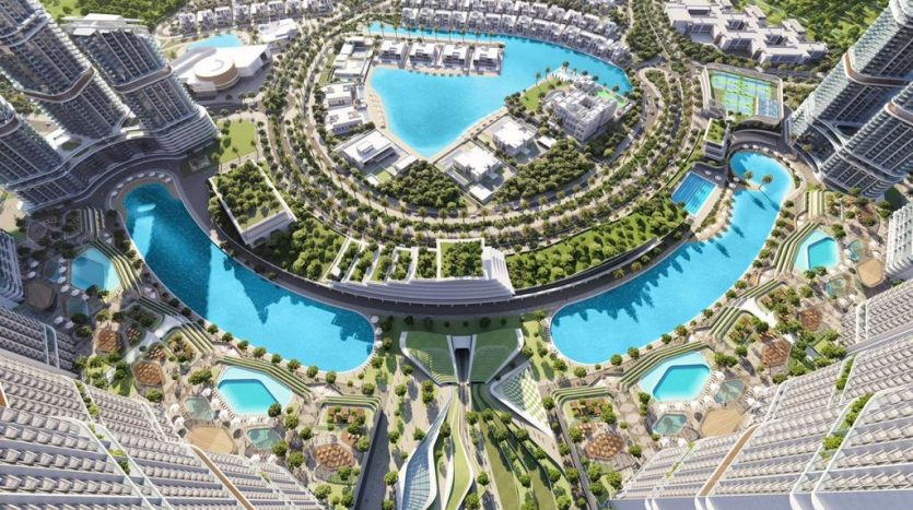 Vue aérienne d&#039;un paysage urbain moderne et futuriste avec des gratte-ciel entourant un lagon artificiel central aux eaux turquoise, reliés par des ponts et aménagés avec une verdure luxuriante, comprenant des villas exclusives à