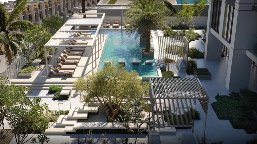 Vue aérienne d&#039;une piscine extérieure moderne entourée de chaises longues luxueuses, d&#039;espaces de jardin géométriques et d&#039;éléments architecturaux élégants dans un cadre immobilier urbain de Dubaï.